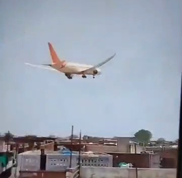 Airplane crash landing near buildings.