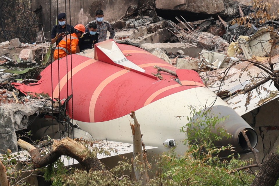 Officials inspecting the wreckage of an Air India plane crash.