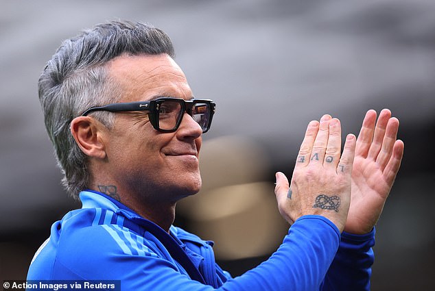Singer Robbie Williams, 51, was also in attendance, wearing a stylish bright blue Adidas jacket as he clapped on the pitch