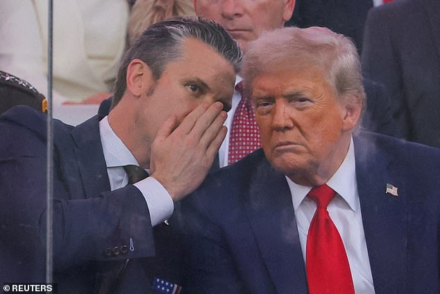 U.S. Secretary of Defense Pete Hegseth talks to U.S. President Donald Trump during the U.S. Army's 250th Birthday parade, on the same day of U.S. President Donald Trump 79th birthday, in Washington, D.C., U.S., June 14
