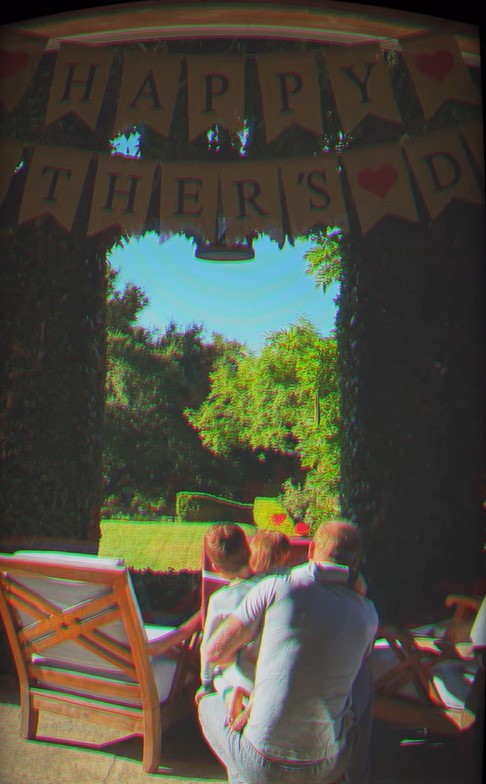 A man embraces two children on a porch swing.