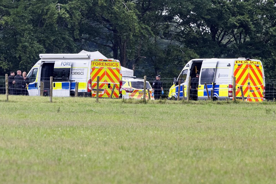Police and forensics vehicles at a skydiving accident scene.