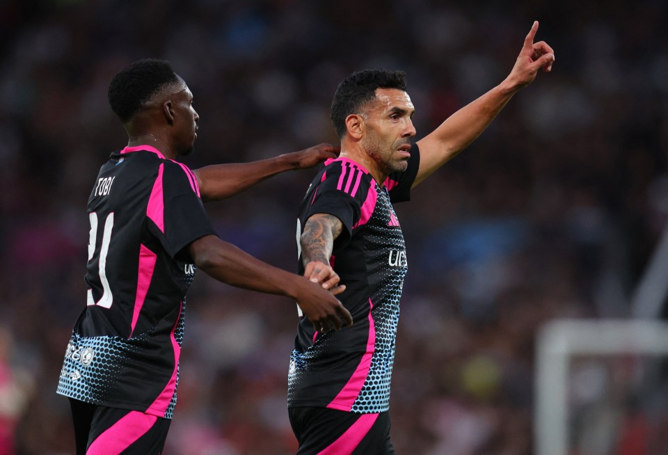 Carlos Tevez celebrating a goal with a teammate at a Soccer Aid match.