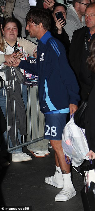 While the I'm A Celeb champ wore a stylish grey tracksuit and shades, Louis was still dressed in his football kit