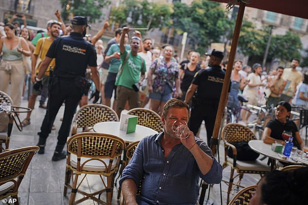 It comes after thousands of locals marched across Spanish islands on Sunday demanding that Brits 'go home' as part of widespread protests against so-called 'over tourism'. Pictured: a tourist in Majorca tries to enjoy his evening meal during Sunday's anti-tourist protest