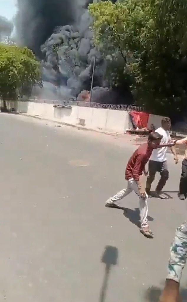 The father was seen wandering the streets as a plume of thick, black smoke towered over him