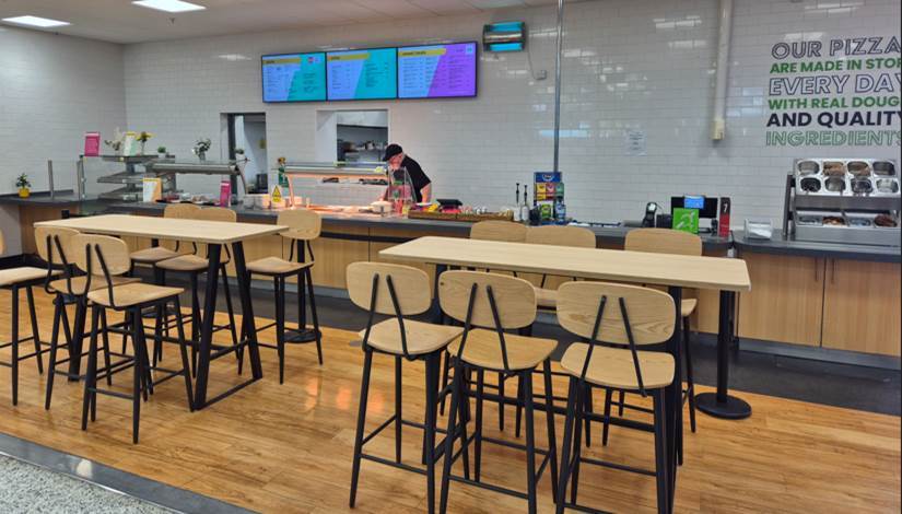 A food court with tall tables and stools.