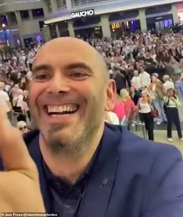 Pictured: Phil's friend filmed a video himself as attendees swarmed the floor below them