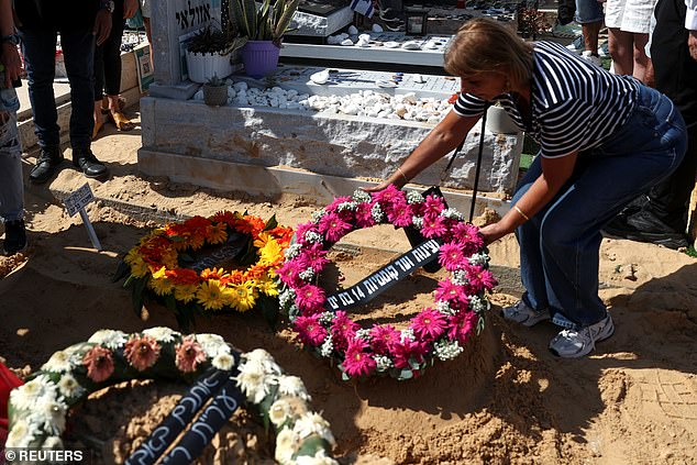 A woman places a wreath on the ground at the funeral of Bella Ashkenazi, who was killed at her home when a missile fired from Iran hit it, in Holon, Israel June 16, 2025