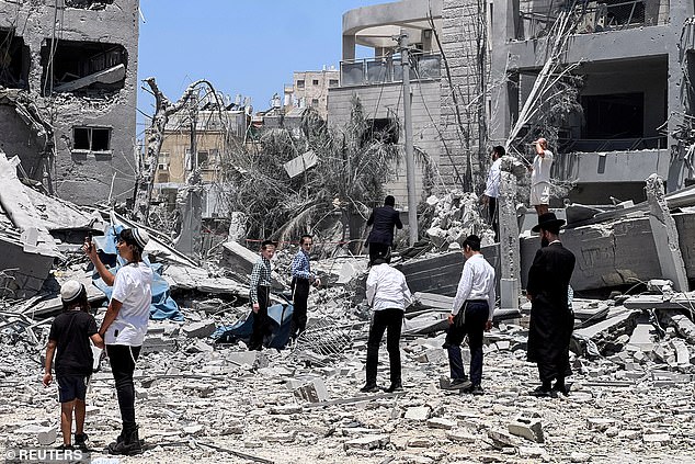Ultra Orthodox jews look at an impacted site following missile attack from Iran on Israel, in Bnei Brak, Israel June 16, 2025