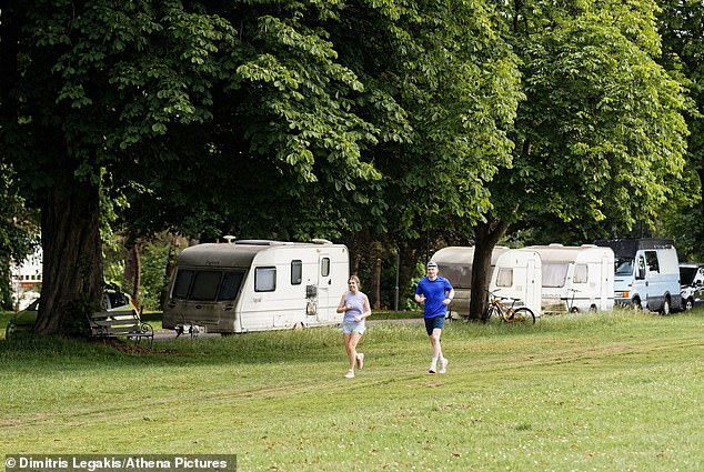 Runners pictured going past some caravans which are plotted up along the side of the park