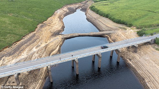 In this aerial view low water levels at Baitings Reservoir reveal the top of an ancient pack horse bridge after the driest spring in 132 years