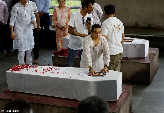 Meena Patel's daughter touches the portrait of her mother, who died in the Air India Boeing 787-8 Dreamliner plane crash during take-off from an airport,in Ahmedabad, India June 16,2025
