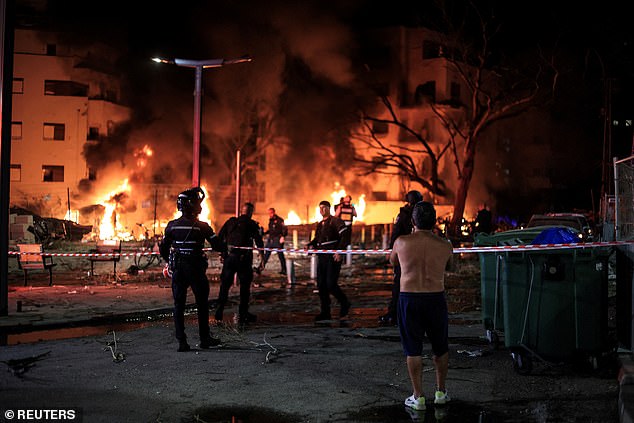 Firefighters and rescue personnel work at an impact site following missile attack from Iran on Israel, in Tel Aviv, Israel June 16, 2025