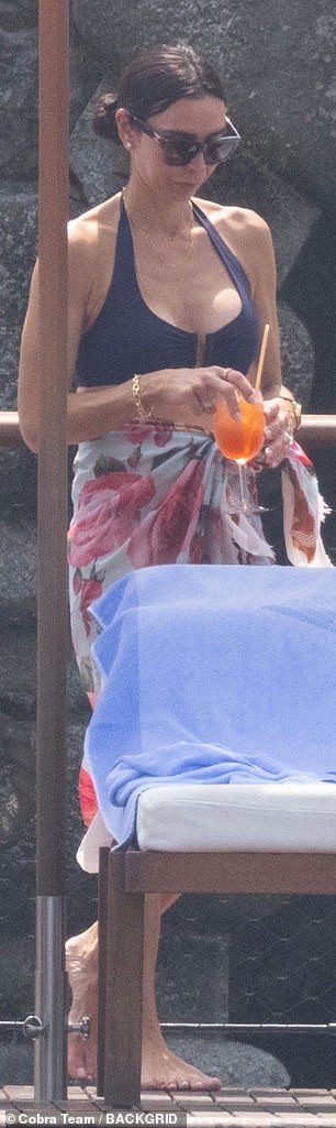 Christine basked in a plunging navy halterneck bikini top with low-rise briefs