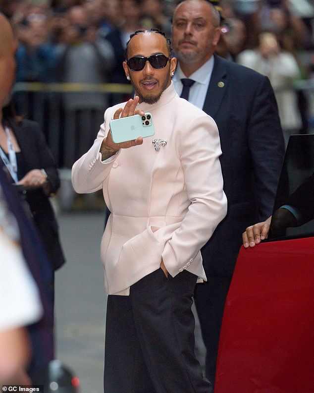 He accessorised with dark sunglasses and diamond earrings