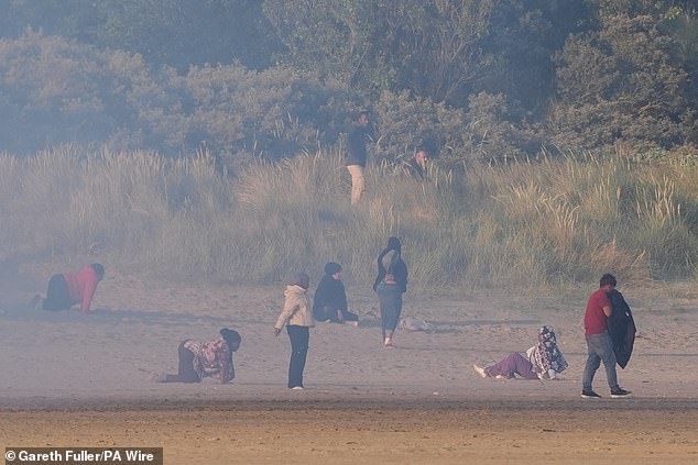 More than 50 police tried to stop as many as 200 migrants reaching the sea
