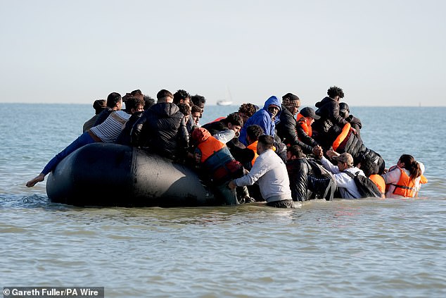 A group of people thought to be migrants on a dinghy near the beach at Gravelines