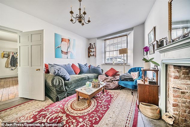 Exposed floorboards continue through to the main reception room where there is an attractive fireplace and wood burning stove