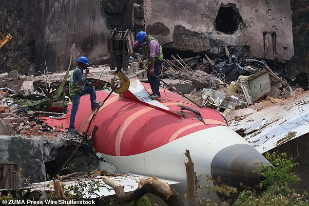 A crane retrieves part of the fuselage of the Air India Boeing 787 on June 14, 2025