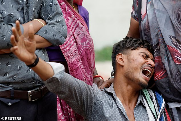 Kalpeshbhai Patni, 28, mourns as he sits outside the postmortem room at a hospital, for his brother Akash Patni, 14, who died when the Air India Boeing 787-8 Dreamliner plane crashed