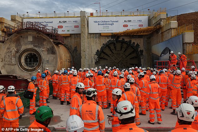 Construction workers and members of the media look on moments after tunnel boring machine "Cecelia" breaks through, after tunnelling under the Chiltern Hills