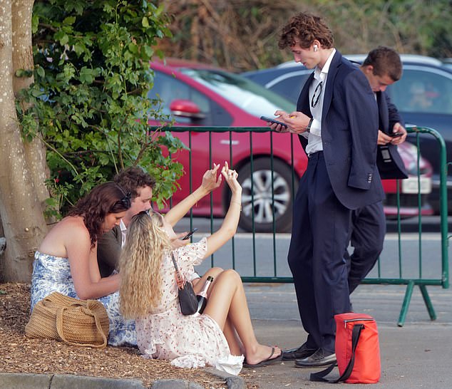 Elsewhere, a group of ladies were seen sat on dry grass at the end of the first day of the festival with one of them seemingly carrying a bottle of bubbly