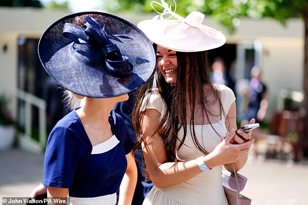 Having a laugh! Two friends share a giggle as they arrive at the prestigious racing event