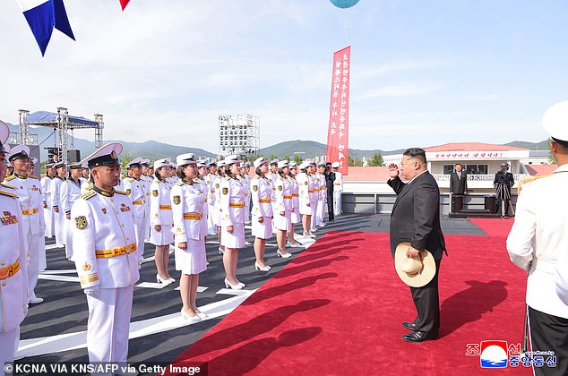 This picture taken on June 12, 2025 and released from North Korea's official Korean Central News Agency (KCNA) via KNS on June 13, 2025 shows North Korea's leader Kim Jong Un (2nd R) encouraging sailors at the launch ceremony for the destroyer 'Kang Kon' at the Rajin shipyard at the port near Rason in North Korea