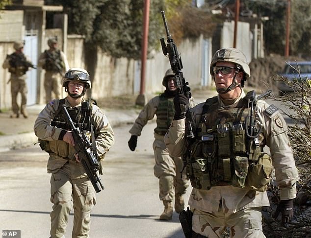 Kurilla, right, is nicknamed 'The Gorilla' and is shown above with his soldiers pursuing an insurgent sniper after two soldiers were shot and wounded, one in the hand and one in the leg, in Mosul, Iraq, February 10, 2005