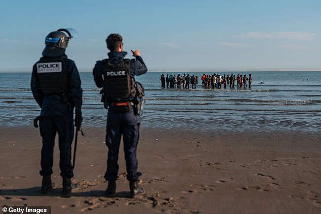 Scores of migrants were hauled aboard as police and officials watched, from land and four sea craft, without doing anything