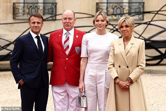 President Emmanuel Macron, Prince Albert, Princess Charlene and the First Lady of France huddle together at last year's Paris Olympics opening ceremony