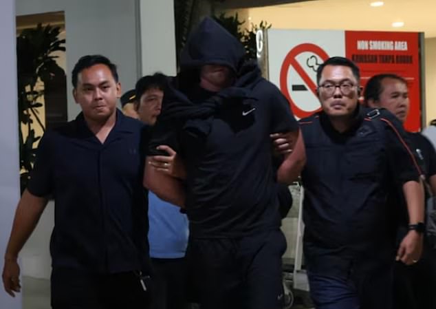 One of the suspected gunmen was extradited back to the holiday island in handcuffs (pictured)
