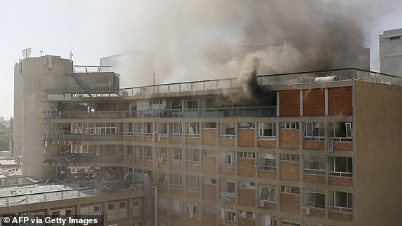 TOPSHOT - Smoke billows from Soroka Hospital in Beersheba in southern Israel following an Iranian missile attack, on June 19, 2025. A hospital in southern Israel was hit during a barrage of "dozens" of Iranian missiles on June 19, officials said, while another impact was reported by emergency services in the Tel Aviv area. (Photo by John Wessels / AFP) (Photo by JOHN WESSELS/AFP via Getty Images)