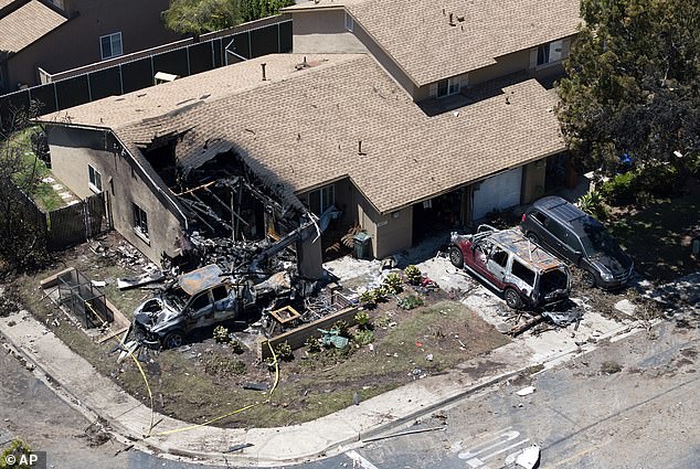 A house is damaged after a small plane crashed into a neighborhood, setting homes and vehicles on fire on May 22, 2025 in San Diego, California