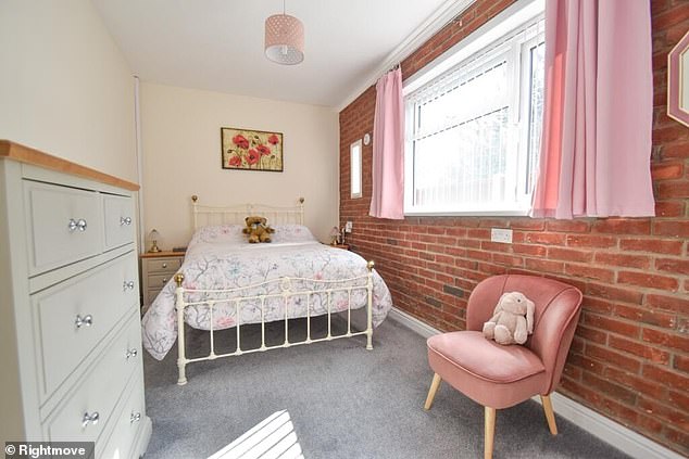 A smaller bedroom comes with a stylish unpainted brick wall