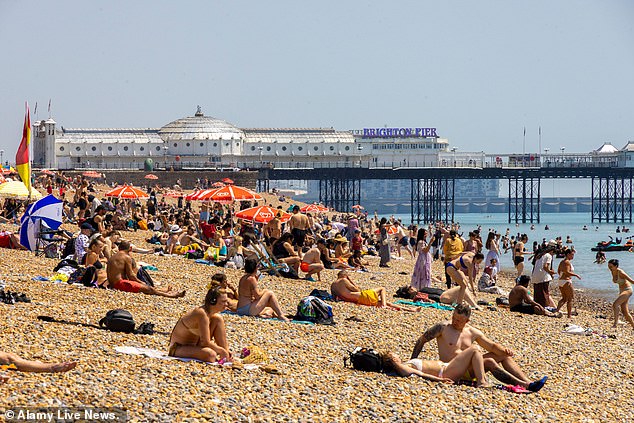People flock to Brighton Beach to top-up their tan and enjoy soaring temperatures