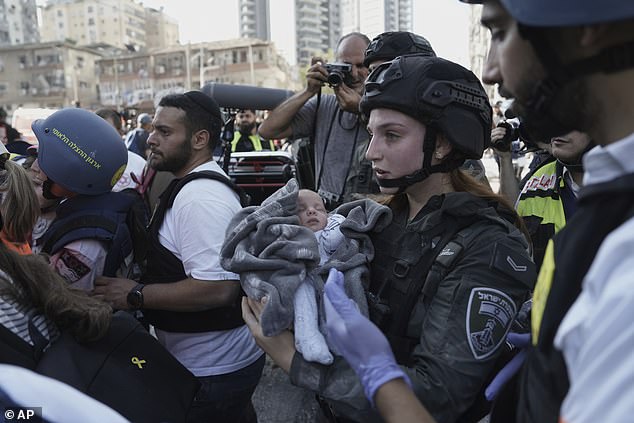 A baby is evacuated from the site of a direct hit from an Iranian missile strike in Ramat Gan, Israel, Thursday, June 19