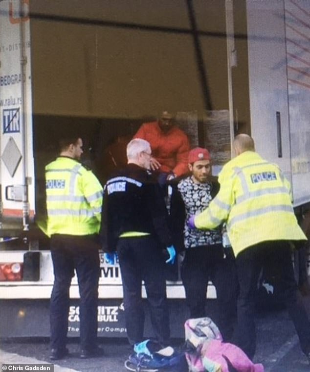 Men are escorted out of a lorry by police on Chris' farm, in a photo taken by the man dubbed 'the Farminator'