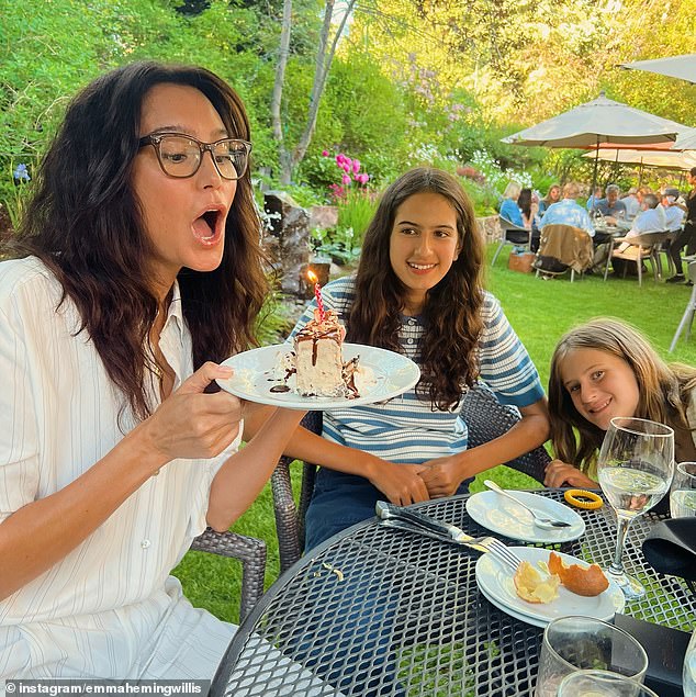Another picture was taken as Emma - who officially turned one year older on June 18 - blew out a candle on top of a sugary slice of cake as the group spent time outside at a restaurant