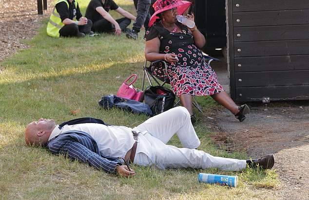 A man sprawls out on the grass with a can of Pringles just out of reach