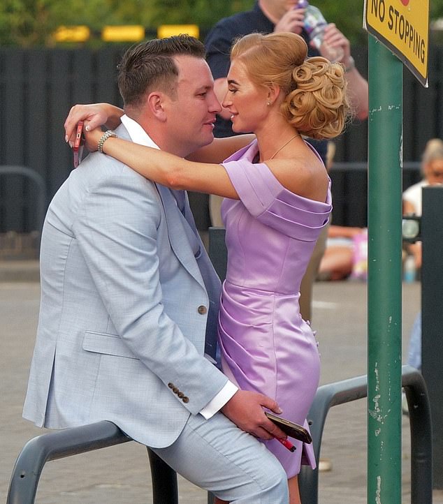 A young couple enjoy a loving moment away from the races with a vape in hand