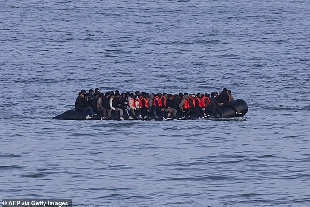 Migrants sail onboard a boat in an attempt to cross the English Channel off the beach of Neufchatel-Hardelot, northern France on June 18