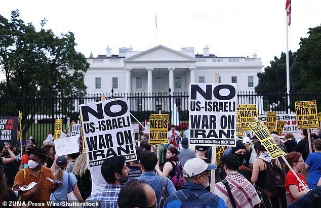 Demonstrators hold signs outside the White House in Washington DC