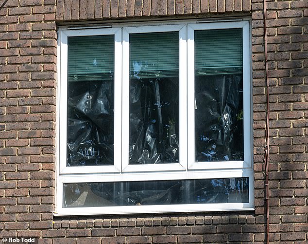 The flat's windows were seen blocked out with plastic sheeting on Thursday