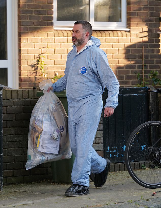 A forensics officer seen carrying a large bag of evidence from Ms Abbott's flat