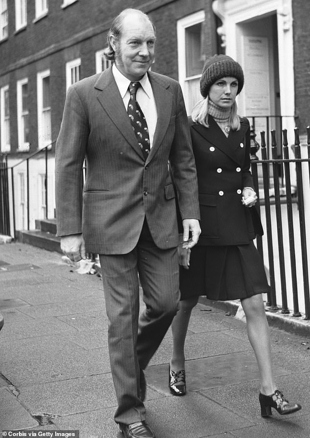 John Aspinall walks down a street in London with his wife Lady Sarah, 1974