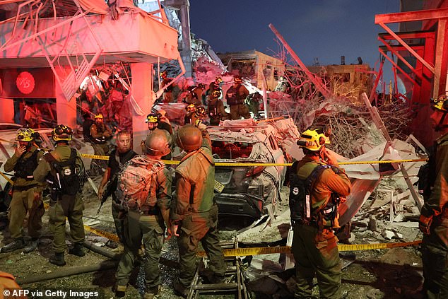 Responders work amid building rubble following a strike by an Iranian missile on June 15