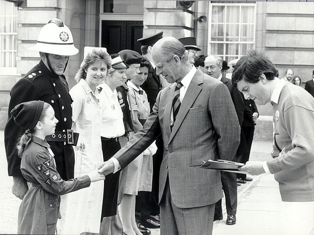 Philip is introduced to brownie Carmella McGowan by Gyles Brandreth at Buckingham Palace in 1987