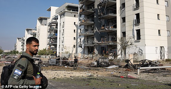 A member of the Israeli security forces checks the destruction at site of an Iranian missile attack in a residential area in Beersheba in southern Israel, on June 20, 2025. Israel and Iran exchanged fire again on June 20, a week into the war between the longtime enemies. (Photo by MAYA LEVIN / AFP) (Photo by MAYA LEVIN/AFP via Getty Images)
